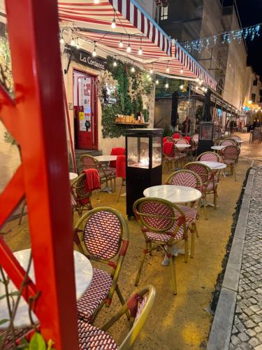 an empty restaurant with tables and chairs under a tent at Heart of Cascais Cozy 2BR Steps from Beach in Cascais