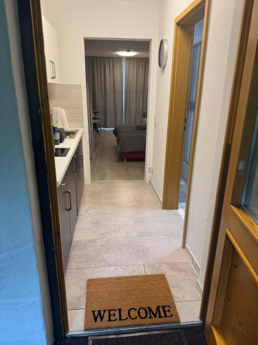 a door to a kitchen with a welcome mat on the floor at Gemütliche Ferienwohnung mit Blick auf die Donau in Obernzell