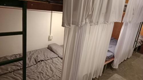 a bedroom with two bunk beds with white curtains at Reaksa Hostel & Spa - Koh Rong in Kaôh Rŭng (6)