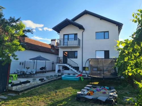 a large white house with a yard with a pool at Casa Marm in Călimăneşti