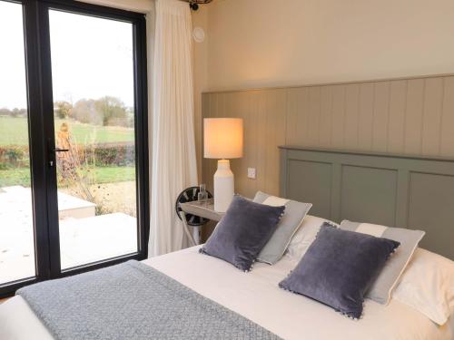 a bedroom with a bed with blue pillows and a window at Fairview in Saxmundham