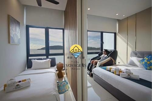 a man sitting in a chair in a room with two beds at Sea Park LeSu 8 The Shore KK I 1 plus 1 Room 2-5 Pax 홈스테이 in Kota Kinabalu