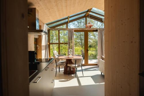 una cucina e una sala da pranzo con tavolo e sedie di Large Greenhouse op Boetiekpark de Kas a Scherpenzeel