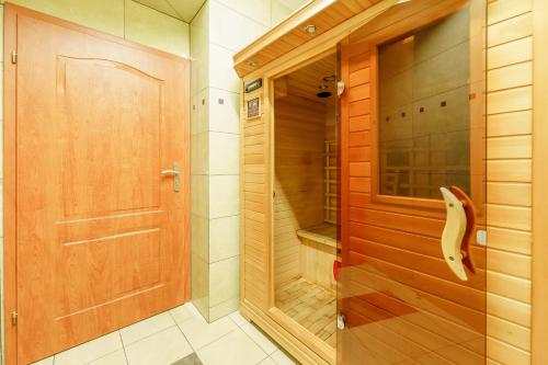 Centrum Rehabilitacyjno - Wczasowe Amber في كولوبرزيغ: عليك المشي في الحمام مع باب خشبي