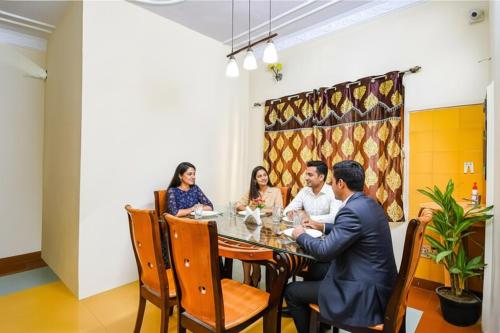a group of people sitting around a table in a restaurant at FabHotel Heritage Inn in Kolkata