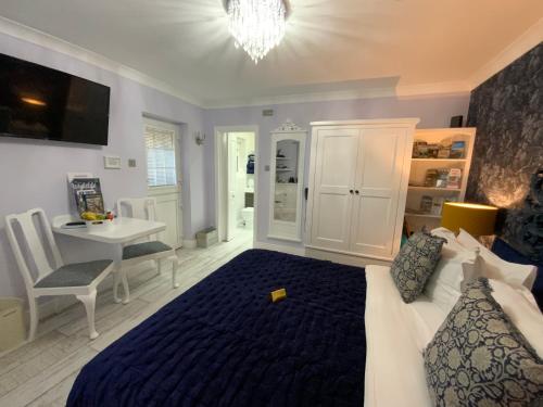 利明顿THE KNIGHTWOOD OAK a Luxury King Size Bed - En-Suite Space - LYMINGTON NEW FOREST with Totally Private Entrance - Key Box entry - Free Parking & Private Outdoor Seating Area - Town ,Shops , Pubs & Solent Way Walking Distance & Complimentary Breakfast的一间卧室，配有一张床、一张桌子和一张书桌