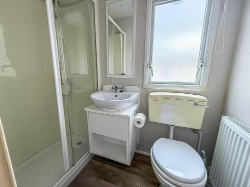 a bathroom with a toilet and a sink and a shower at Great 8 Berth Caravan For Hire At Seawick Holiday Park In Essex Ref 27227Sw in Clacton-on-Sea