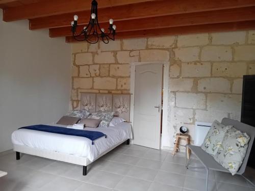 a bedroom with a bed and a stone wall at Le chene vert in Saint-Front-de-Pradoux