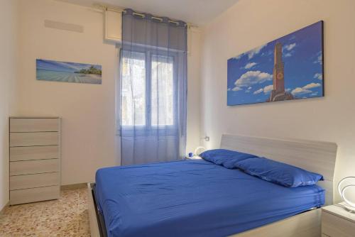 ein Schlafzimmer mit einem blauen Bett und einem Fenster in der Unterkunft Peace House - Relax a Due Passi dal Mare in Finale Ligure