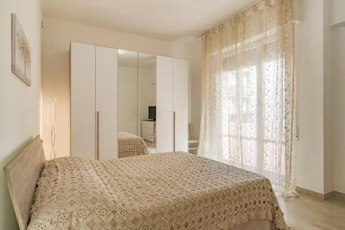 ein Schlafzimmer mit einem Bett und einem großen Fenster in der Unterkunft Peace House - Relax a Due Passi dal Mare in Finale Ligure