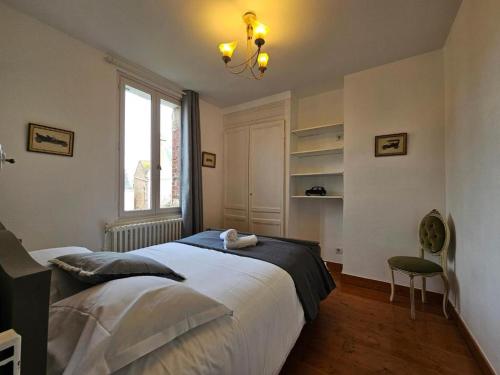 a bedroom with a large bed and a window at Petit Soleil du matin in Étretat