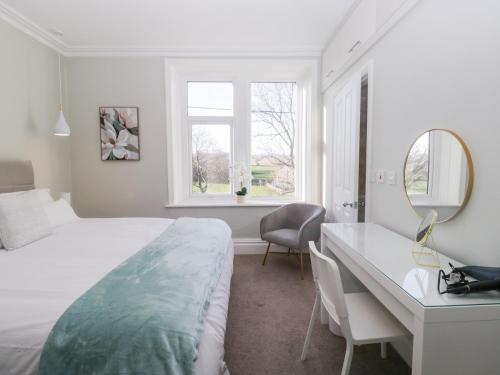 ein Schlafzimmer mit einem Bett, einem Schreibtisch und einem Spiegel in der Unterkunft Rocklands in Shap