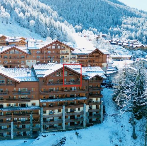 ein Hotel im Schnee mit schneebedeckten Gebäuden in der Unterkunft Élégant Duplex - Sainte Foy Station - 10 pers in Sainte-Foy-Tarentaise
