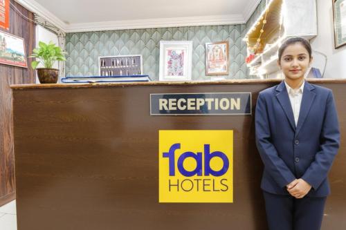 Una mujer con traje parada frente a un mostrador de recepción. en Via Golden Wings, en Udaipur