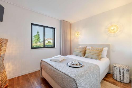 une chambre avec un lit avec un plateau dessus dans l'établissement Ma-la Beach House by HostWise, à Marinhas