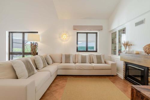 un salon avec un canapé blanc et une cheminée dans l'établissement Ma-la Beach House by HostWise, à Marinhas