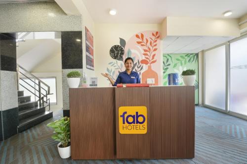 eine Frau steht hinter einem Empfangstresen in einem Büro in der Unterkunft Hotel Supreme in Gurgaon