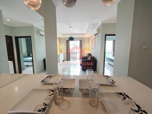 a dining room with a table with glasses on it at Strategic 1BR Bellezza Apt Green Gem Max 6 in Jakarta