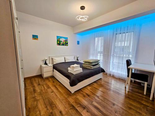 a bedroom with a bed and a desk and window at Ana Residence in Timişoara