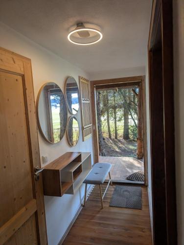 ein Zimmer mit einer Tür, einem Tisch und einem Stuhl in der Unterkunft Sommerstall in Aichstetten