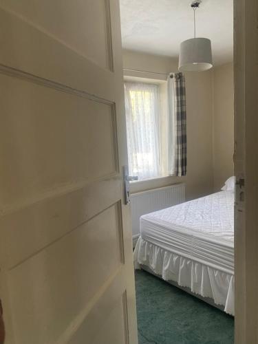 ein Schlafzimmer mit einem Bett und einem Fenster in der Unterkunft Firs Drive in Cranford