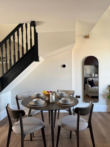 a dining room with a table and chairs and a staircase at Luxury Apartment in Shropshire sleeps 4 in Shrewsbury