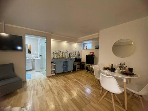 a living room with a table and chairs and a kitchen at Wohlfühlhaus mit Jacuzzi, Fitness, Infrarotkabine, Kamin, Piano, tolle Lage in Vienna