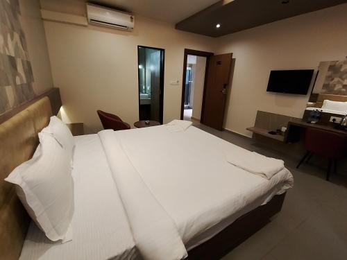 Ένα ή περισσότερα κρεβάτια σε δωμάτιο στο Shettar's Kusum Resort