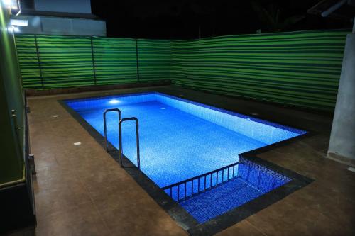 an empty swimming pool at night with blue lights at Josebaa Inn in Vythiri