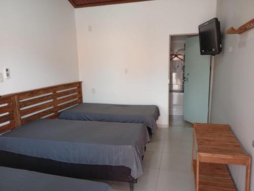 Pousada Vale Canastra في ساو جواو باتيستا دو غلوريا: غرفة بسريرين وتلفزيون وطاولة