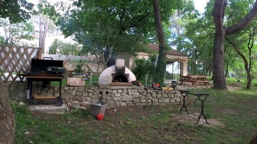 un muro di pietra con forno per pizza in cortile di Gîte du Jonquas a Velleron