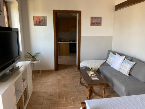 Una sala de estar con un sofá y un televisor de pantalla plana. en Agriturismo Fontelini, en Cingoli