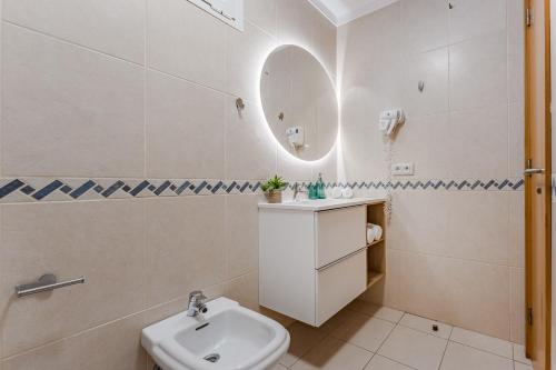 een badkamer met een wastafel, een toilet en een spiegel bij Poseidon 9 - 1 bedroom apartment in Puerto de Santiago