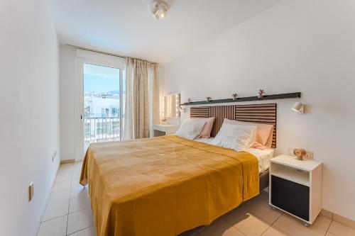 een slaapkamer met een groot bed en een groot raam bij Poseidon 9 - 1 bedroom apartment in Puerto de Santiago