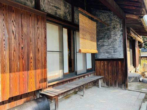 a wooden building with a bench outside of it at 藤花楼akagawa 登録文化財 in Osaka