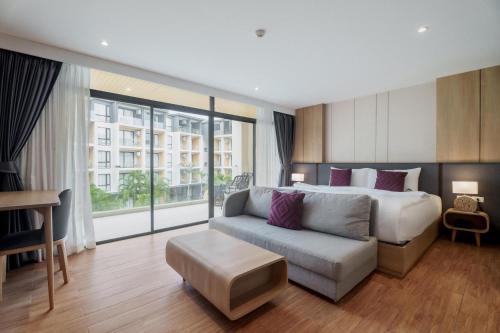 Studio 1525 at Wyndham Garden • Naiton Beach في ناي ثون بيتش: غرفة نوم بها سرير وأريكة