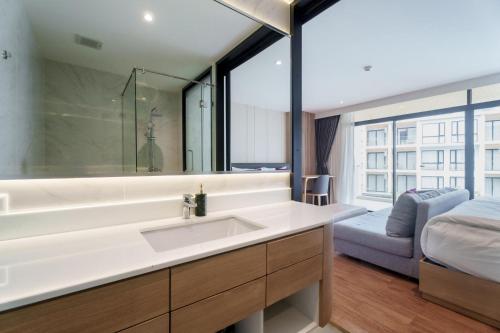 Studio 1525 at Wyndham Garden • Naiton Beach في ناي ثون بيتش: حمام مع حوض ومرآة كبيرة