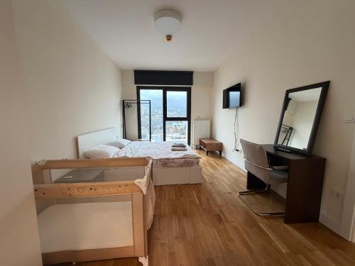 スコピエにあるPanoramic Penthouse Apt in Diamond of Skopjeのベッドと机と鏡のある寝室