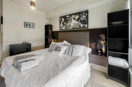 a bedroom with a bed with white sheets and pillows at San Telmo Suites 12 in Buenos Aires