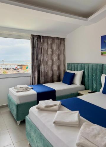 Una habitación de hotel con dos camas y una ventana. en Hotel Santa Paola, en Sarandë