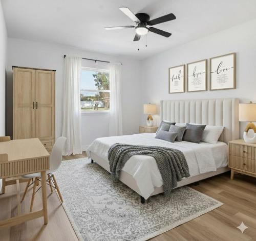 una camera da letto bianca con un letto e un ventilatore a soffitto di Elegant Auburndale Rooms Near the Speedway & Lake Myrtle ad Auburndale