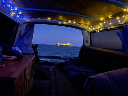 Blick auf den Ozean vom Inneren eines beleuchteten Bootes aus. in der Unterkunft Classical campervan to rent for over 25 years old in Tacoronte