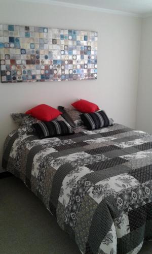 łóżko z czarno-białym kocem i czerwonymi poduszkami w obiekcie Teo Gandolfo Apart w mieście Santiago
