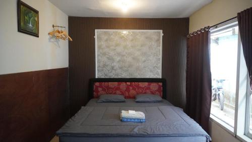 un piccolo letto in una stanza con una finestra di BROMO B&B a Bromo