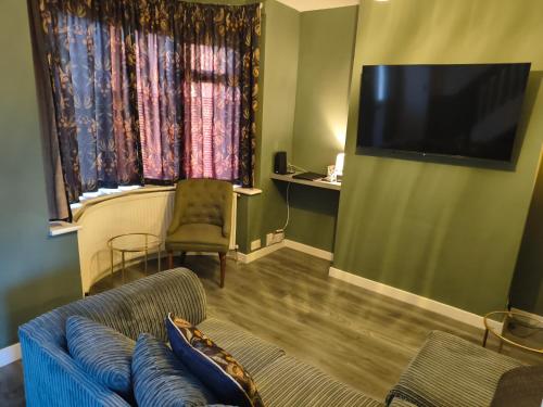 伯明翰Parkdale-Ideal for Birmingham Airport, International Train Station-Resorts World, NEC ,JLR & HS2 sites的配有沙发和平板电视的客厅