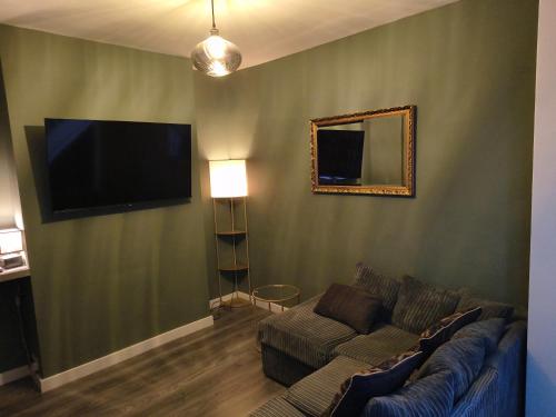 伯明翰Parkdale-Ideal for Birmingham Airport, International Train Station-Resorts World, NEC ,JLR & HS2 sites的配有沙发和平板电视的客厅
