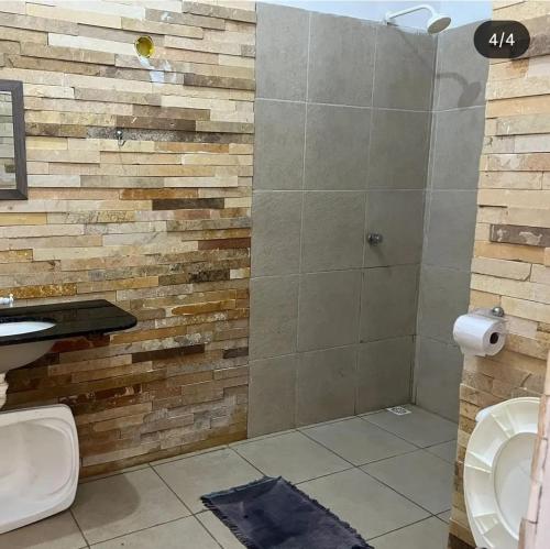 ein Badezimmer mit Dusche und Toilette in der Unterkunft Pousada Pé na Areia Morro Branco in Beberibe