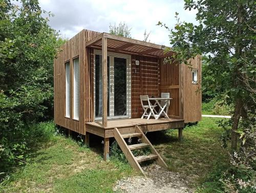 a tiny house with a deck and a table at Studnature in Dunes