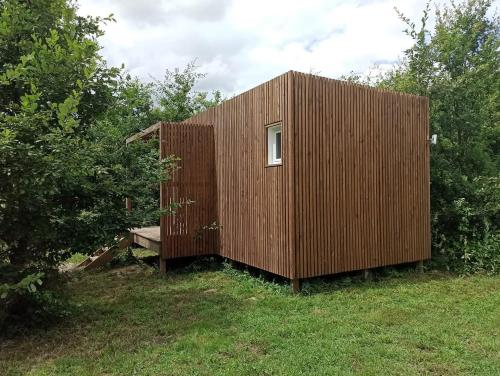 a wooden shed with a bench in a field at Studnature in Dunes