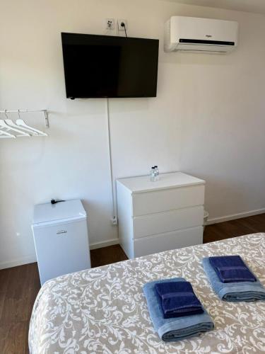a bedroom with a bed with two blue towels on it at Solmare Suites in Albufeira